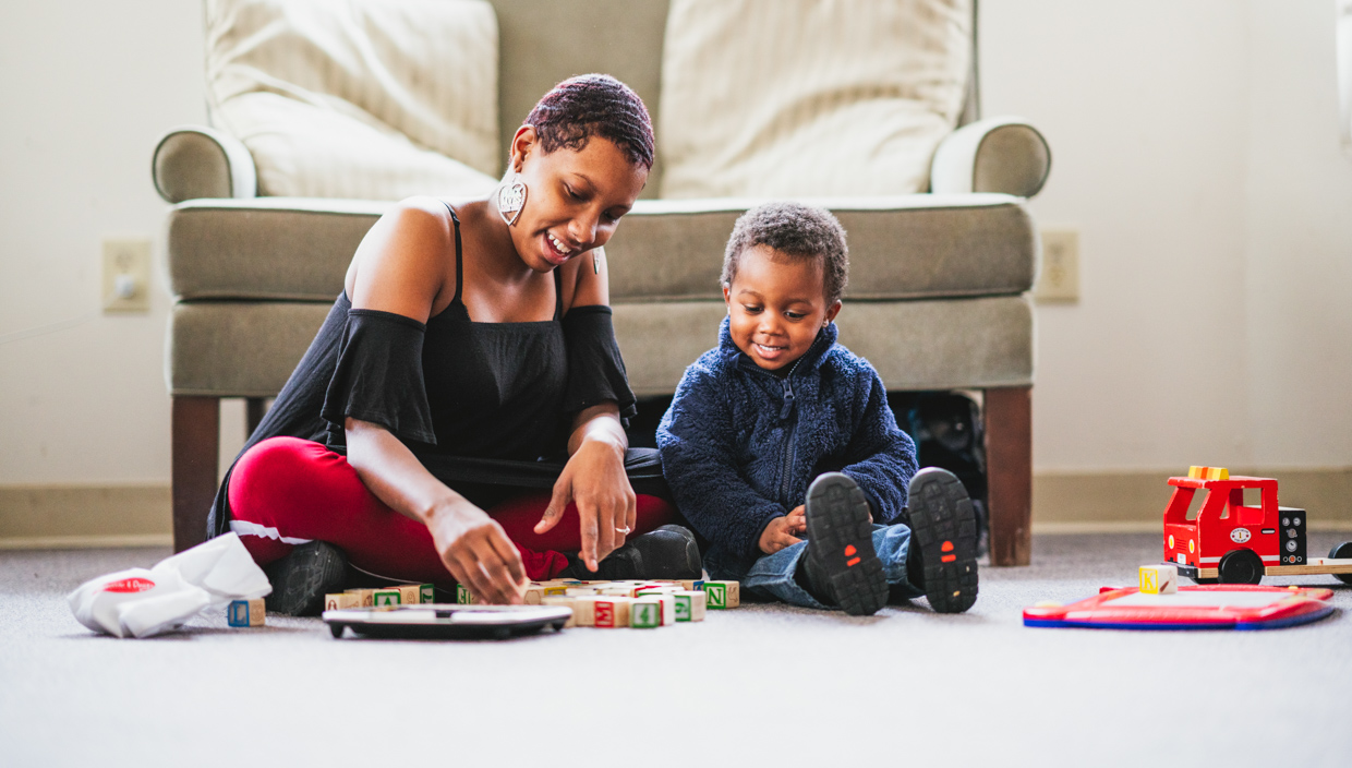 Woman and child play with blocks on the floor